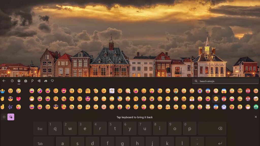 Windows Touch Keyboard switched to the emoji input layout showing a wide grid of smileys.