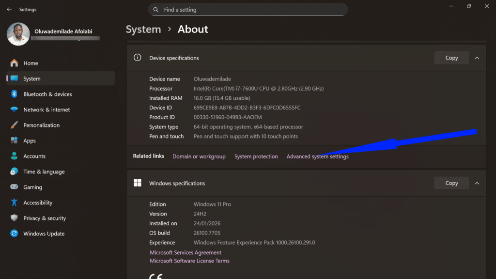 Windows About settings screen with a blue arrow pointing to the Advanced system settings link.