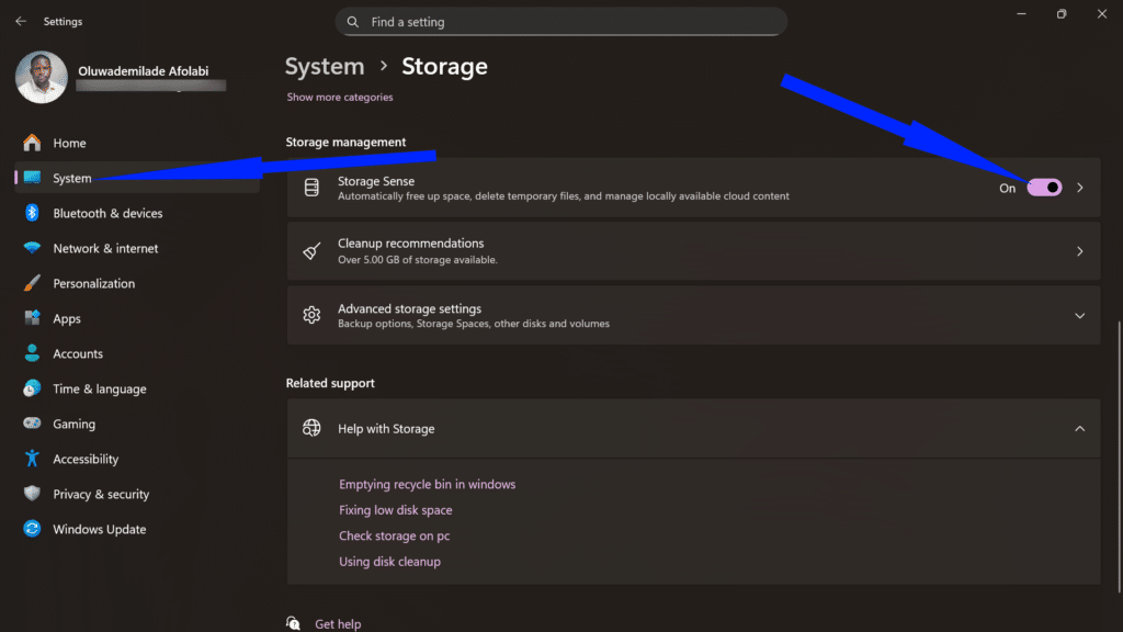 Windows Storage dashboard with a blue arrow highlighting the Storage Sense toggle turned on.